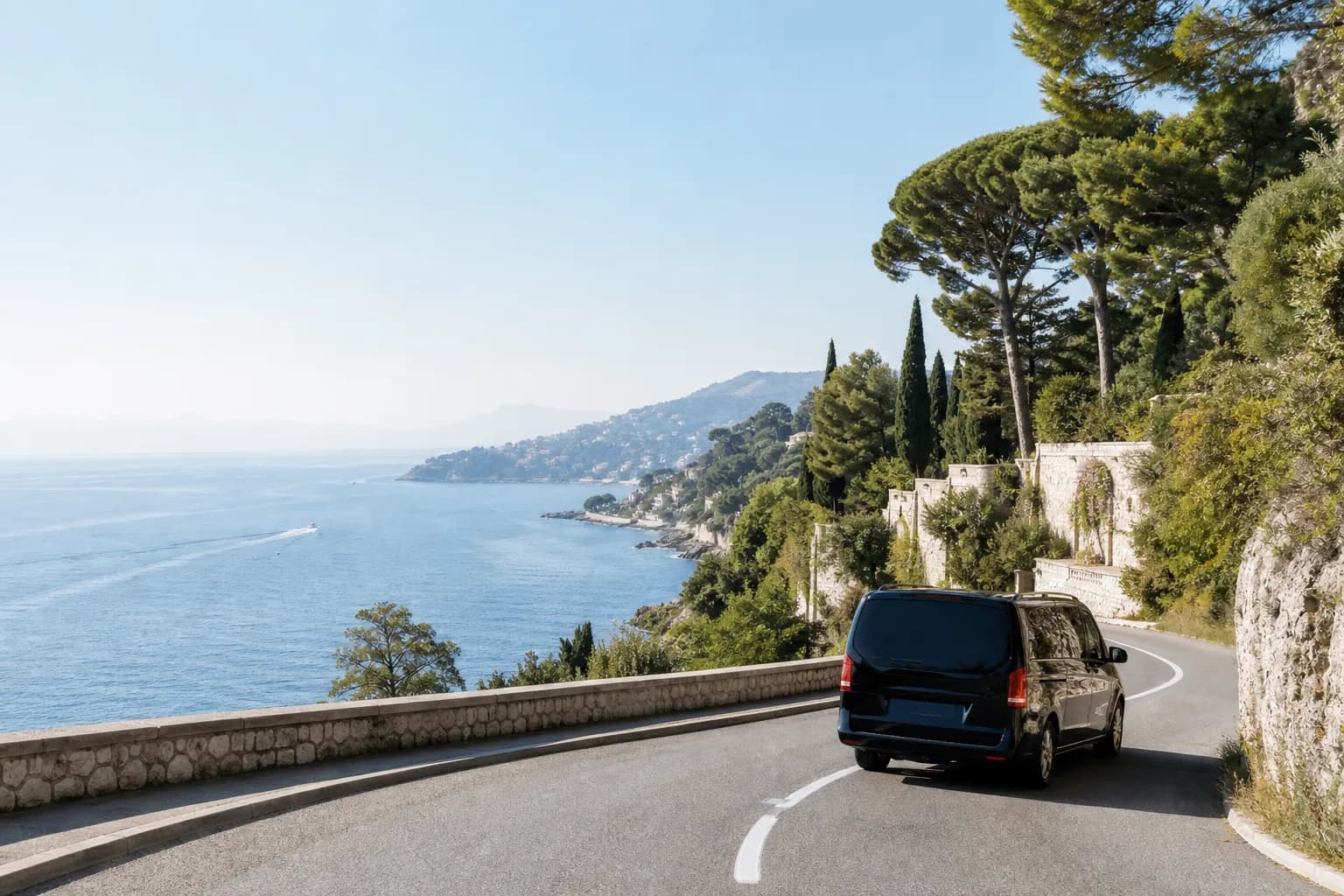 Black chauffeur van on a French Riviera coastal road